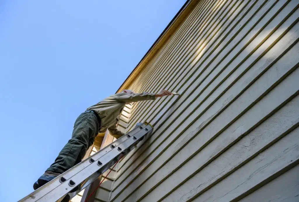 Person som maler hus utvendig