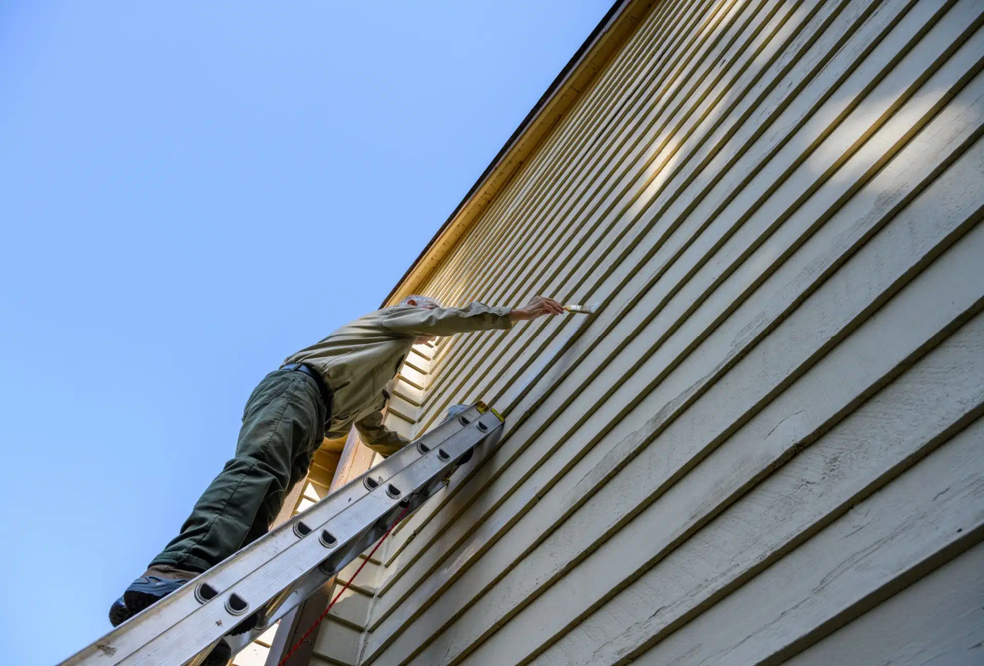 Person som maler hus utvendig